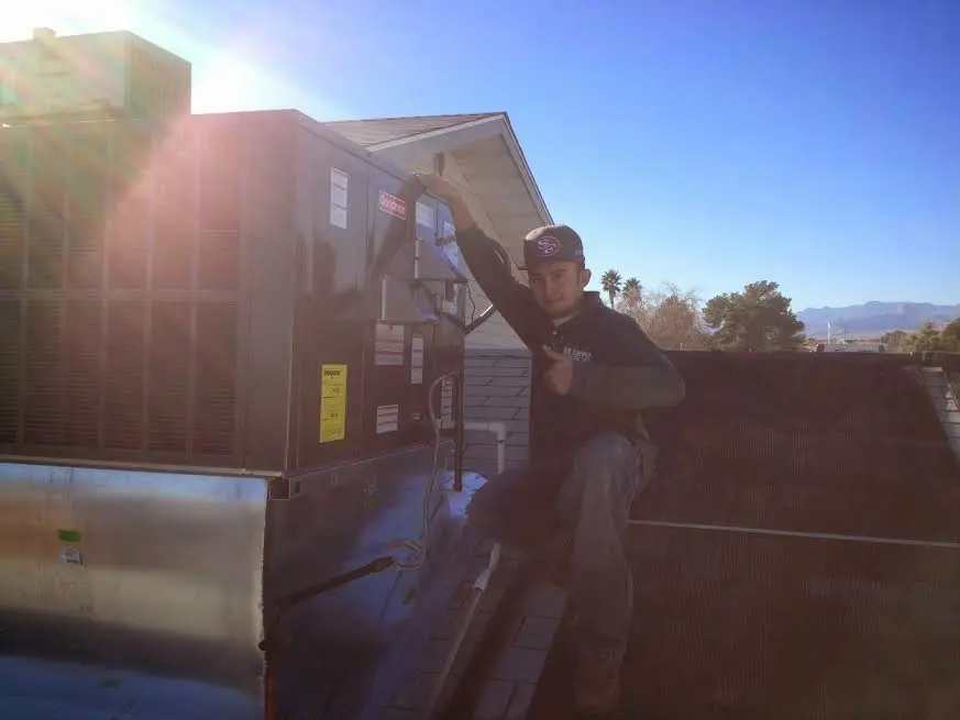 HVAC technician performing Air Duct Cleaning on a rooftop unit in Columbia